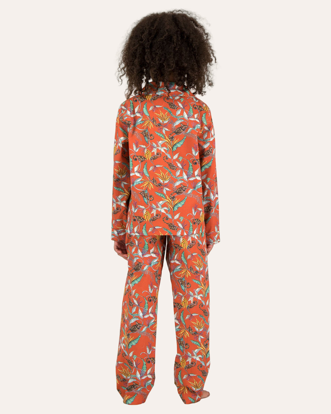 Child wearing long pyjamas with a nag apies orange print on a white background - Woodstock Laundry