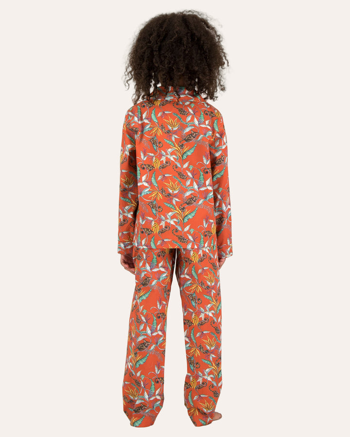 Child wearing long pyjamas with a nag apies orange print on a white background - Woodstock Laundry