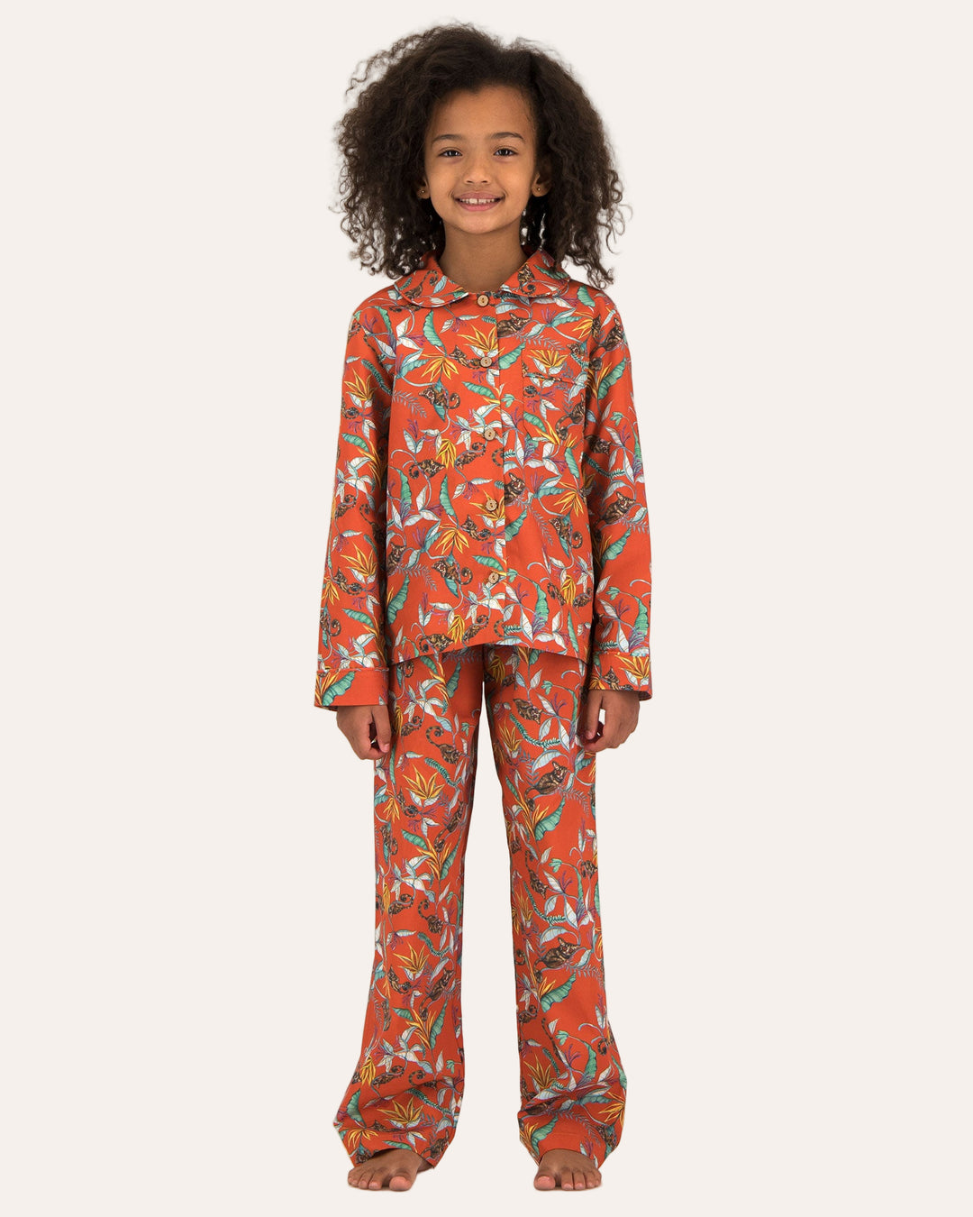 Child wearing long pyjamas with a nag apies orange print on a white background - Woodstock Laundry