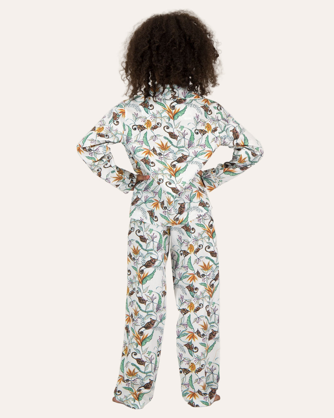 A girl wearing Long Pyjamas with Nag Apies on White Pattern - Woodstock Laundry
