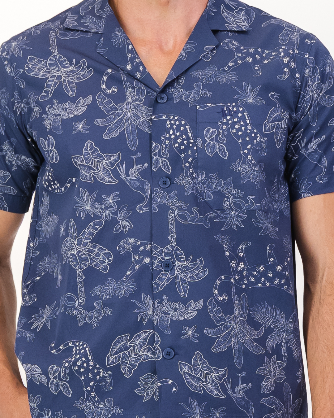 Close-up of signature Woodstock Laundry embroidered chest pocket and organic cotton tropical leopard print fabric detail