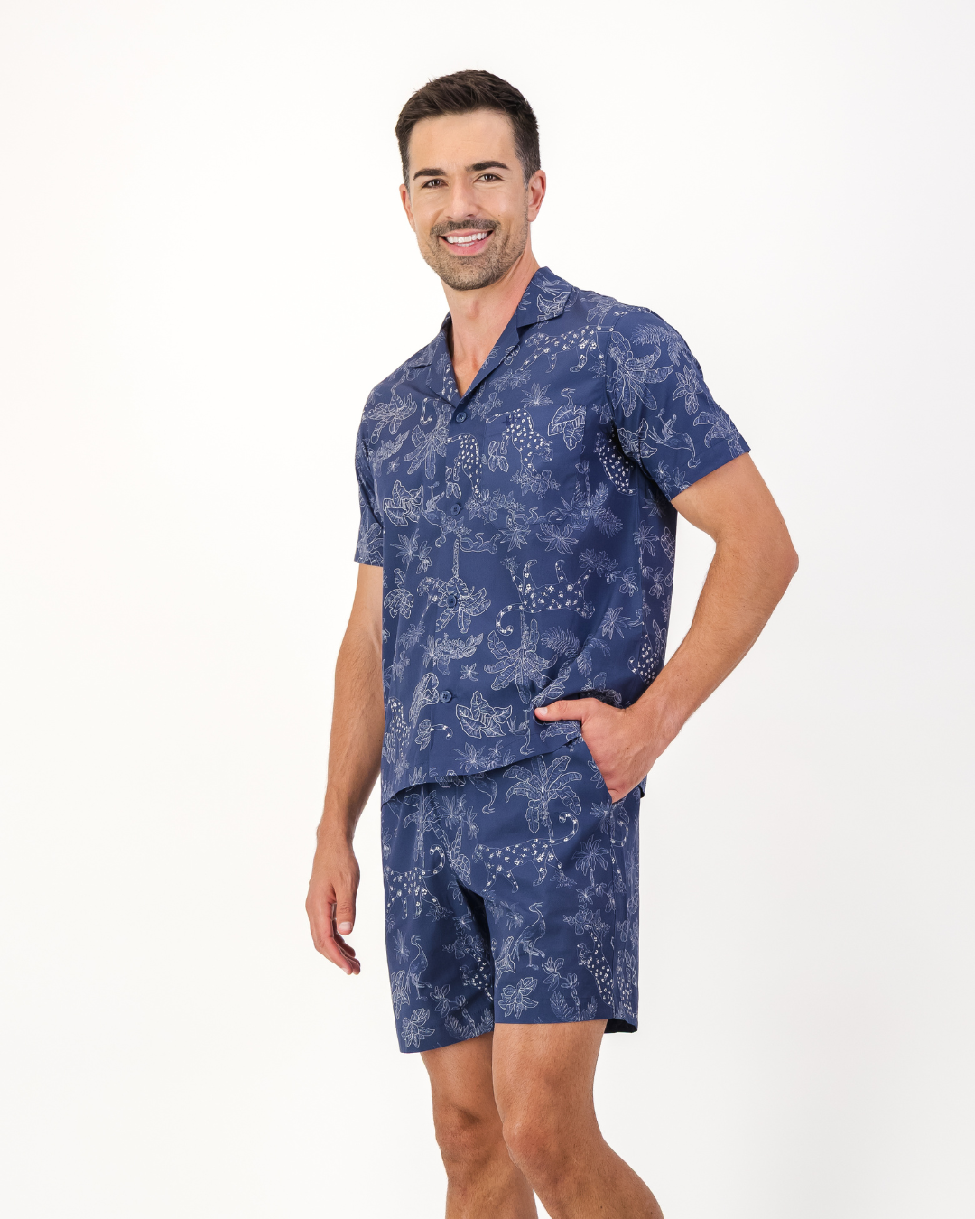 Man wearing navy organic cotton tropical leopard print pyjama set featuring side pockets