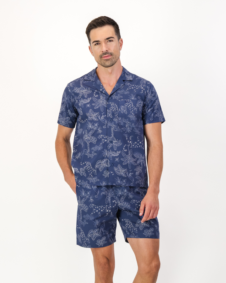 Man wearing a navy blue organic cotton short pyjama set in a tropical leopard print design