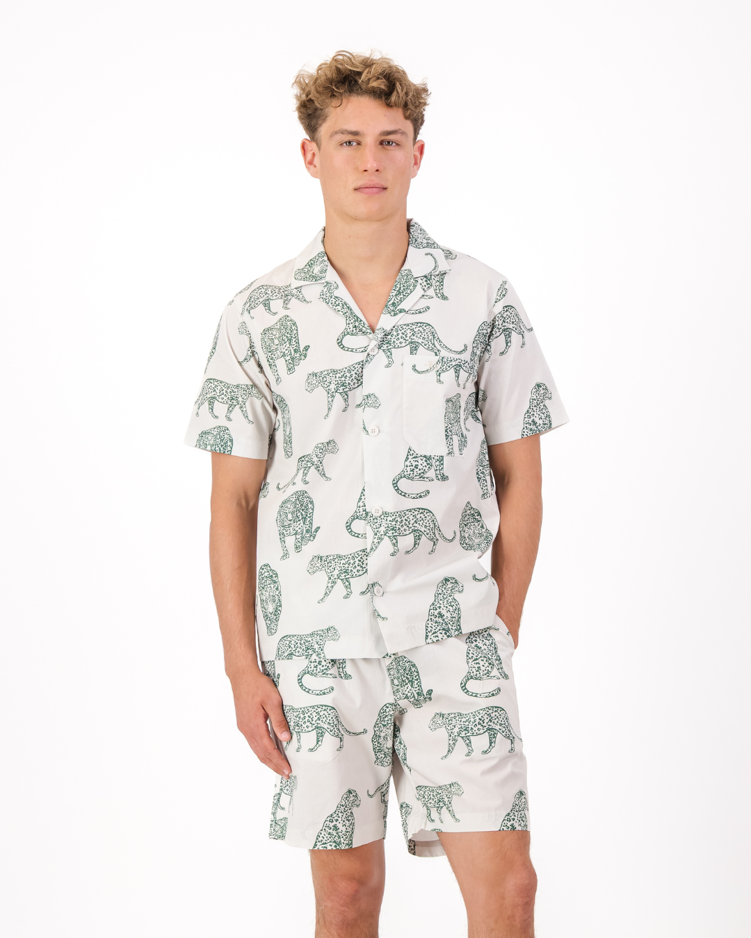 Man wearing a teal leopard print organic cotton pyjama set featuring side pockets