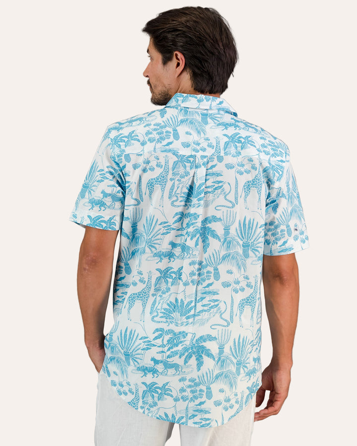 A rear view of a man wearing a Mens Holiday Shirt - Blue Mono Safari on White against a gray background