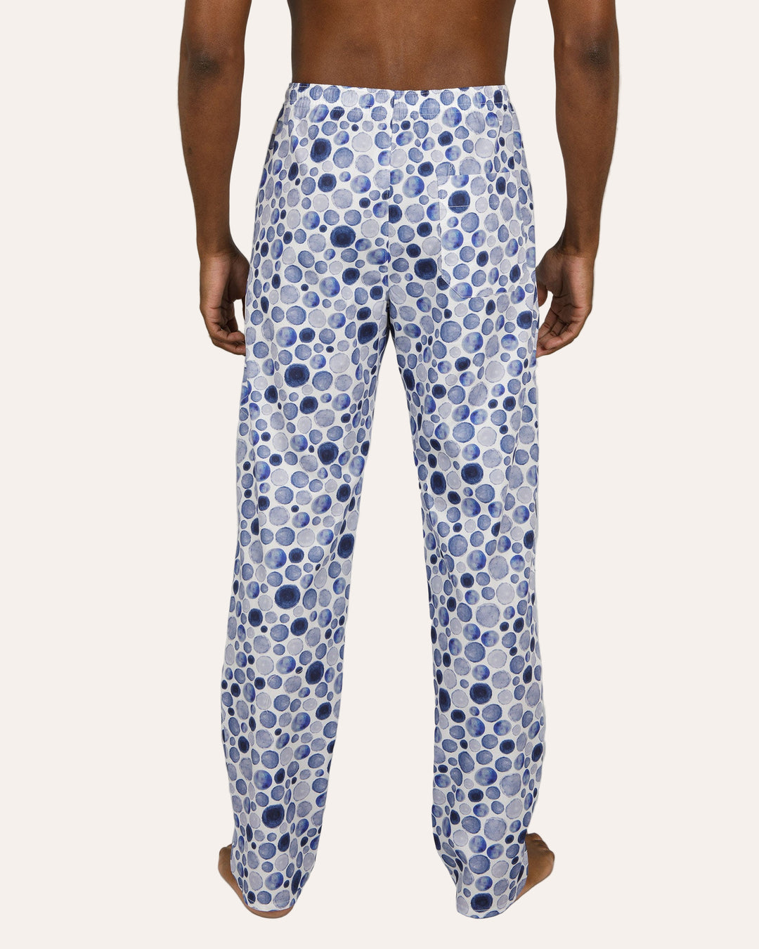 Person wearing blue polka dot pants on a plain background