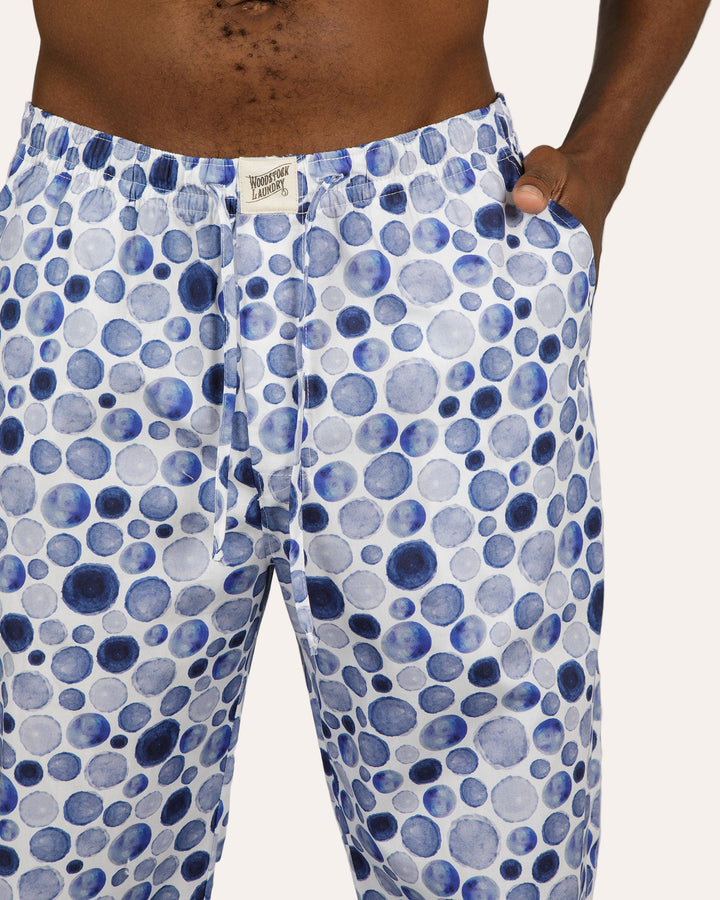 Blue and white patterned pants worn by a person on a gray background