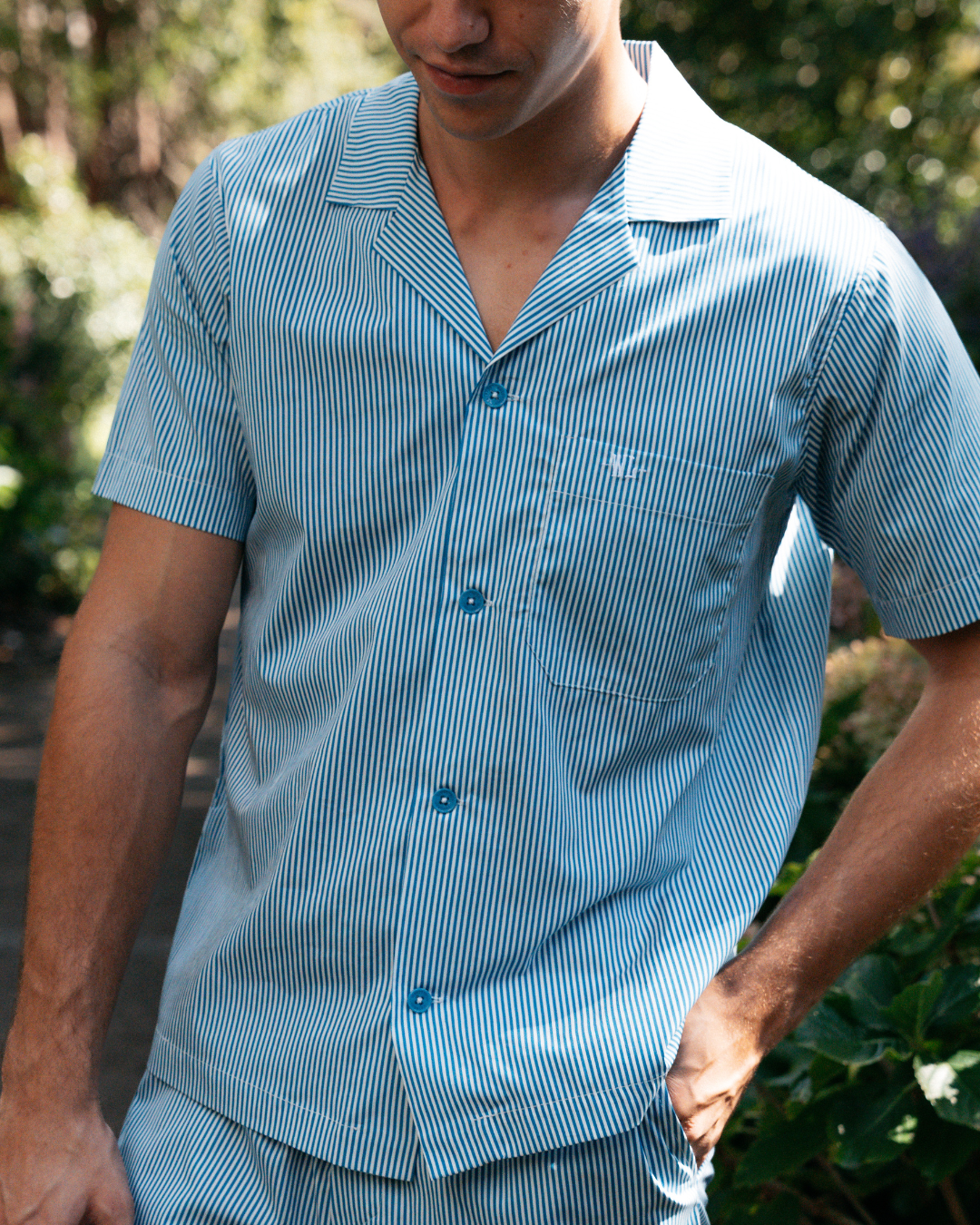 Signature Woodstock Laundry embroidery on a blue and white striped organic cotton pyjama shirt pocket

