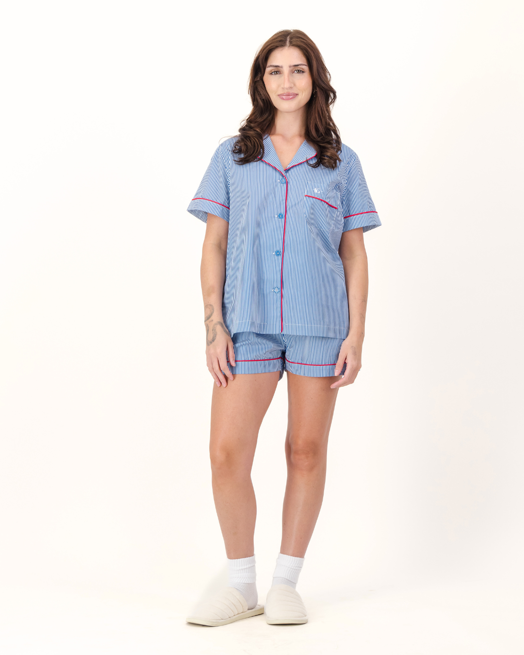 Woman wearing a blue and white striped pajama set with red piping